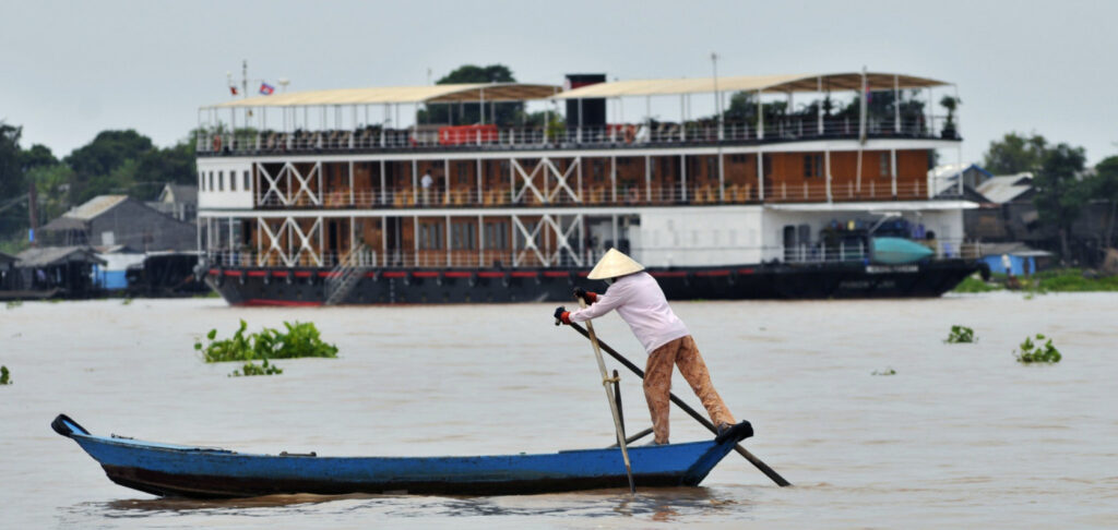 En bild på en man som ror en båt på Mekong